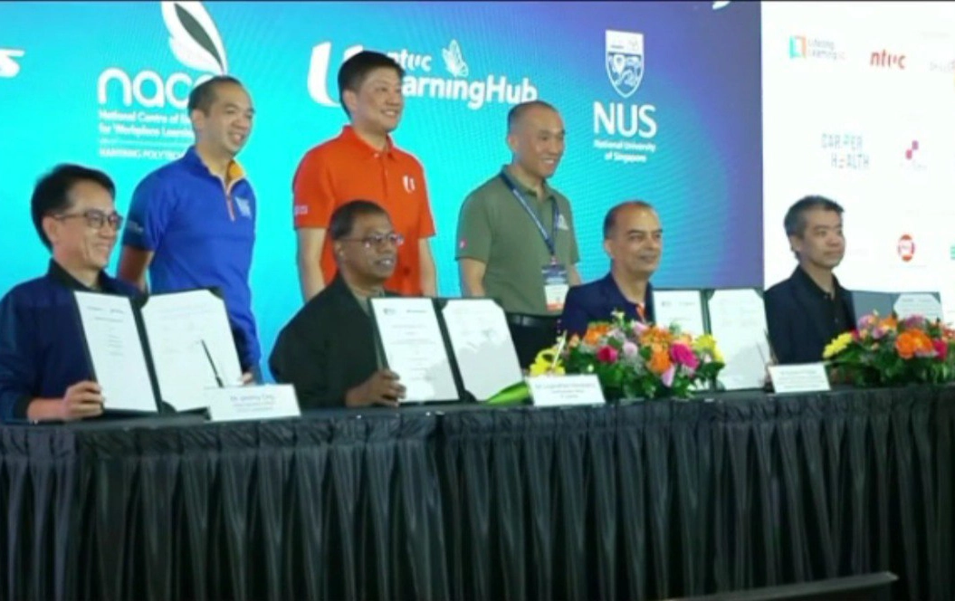 Signing ceremony between NACE led by NYP, NTUC Learning Hub, NUS, and ST logistics. (Credit: Mediacorp/Channel 8 News)