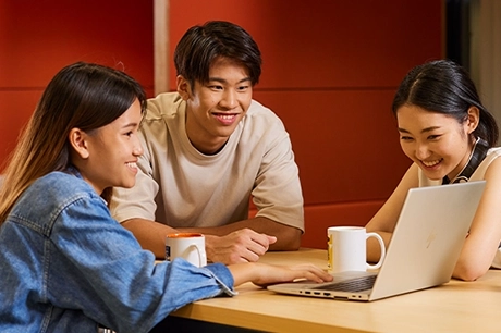 Students looking at laptop together