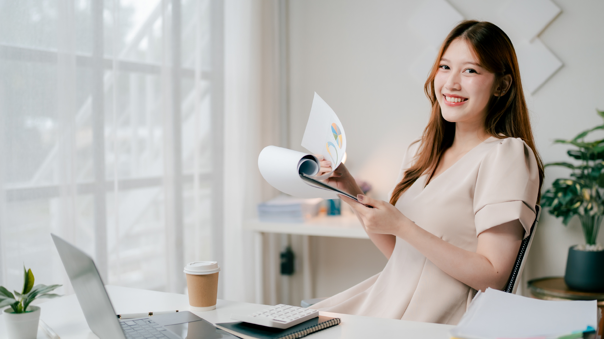 Woman in smart-formal attire holding and flipping her notes with a big smile