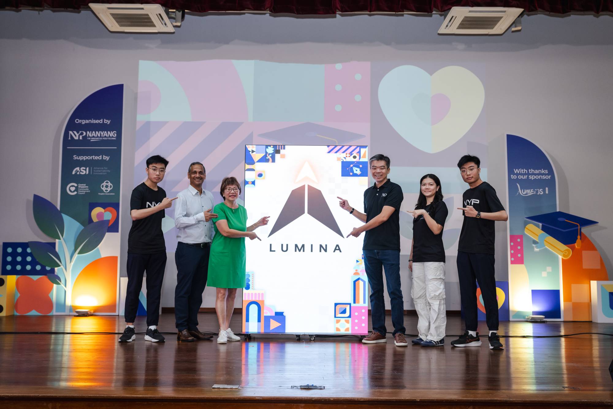Six people on stage pointing at the Lumina launch screen