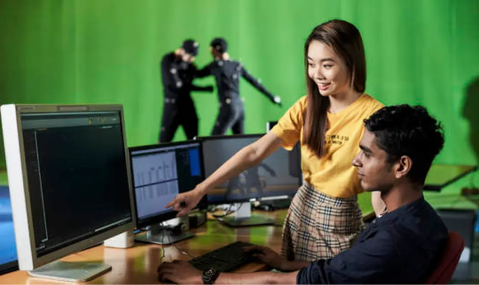 Girl pointing on the screen to a boy