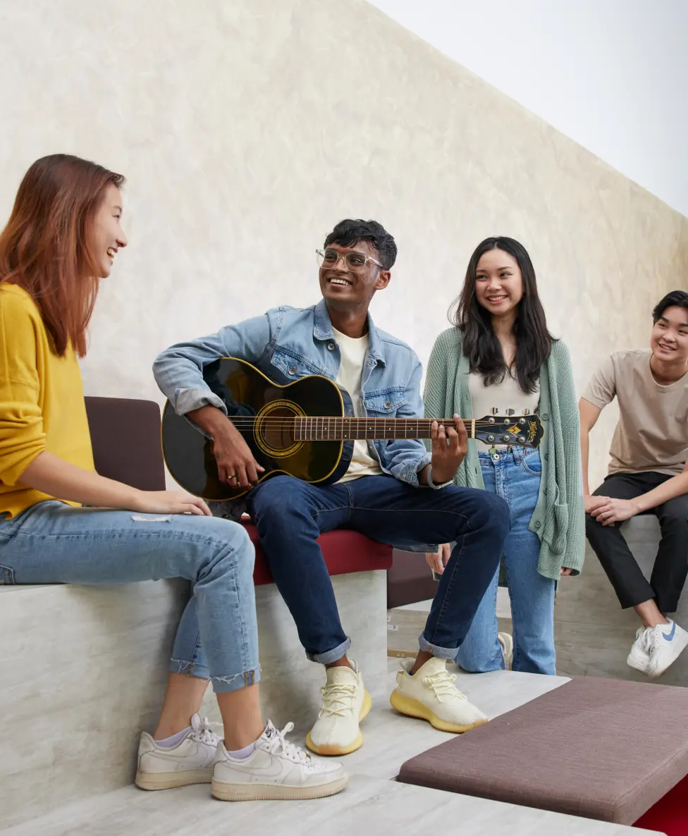 Boy playing guitar with his friends