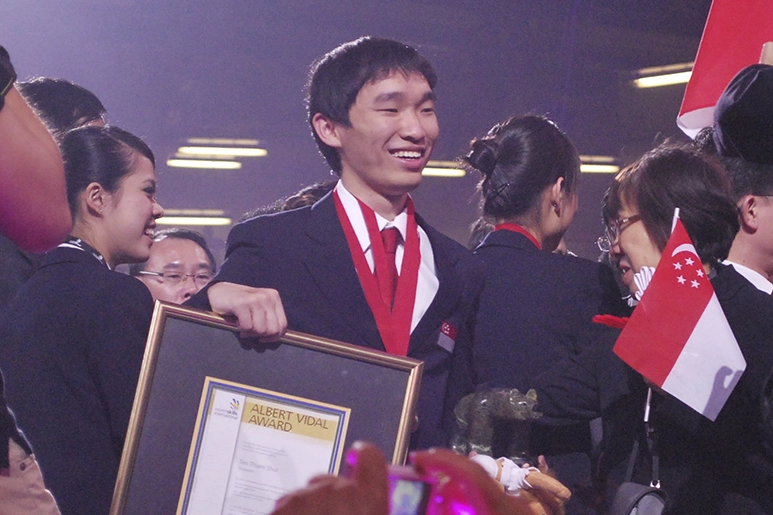 Thiam Shui holding his Albert Vidal award and smiling.