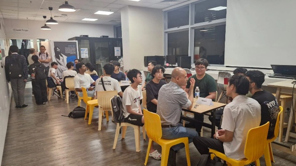 Groups of students with mentors in discussion