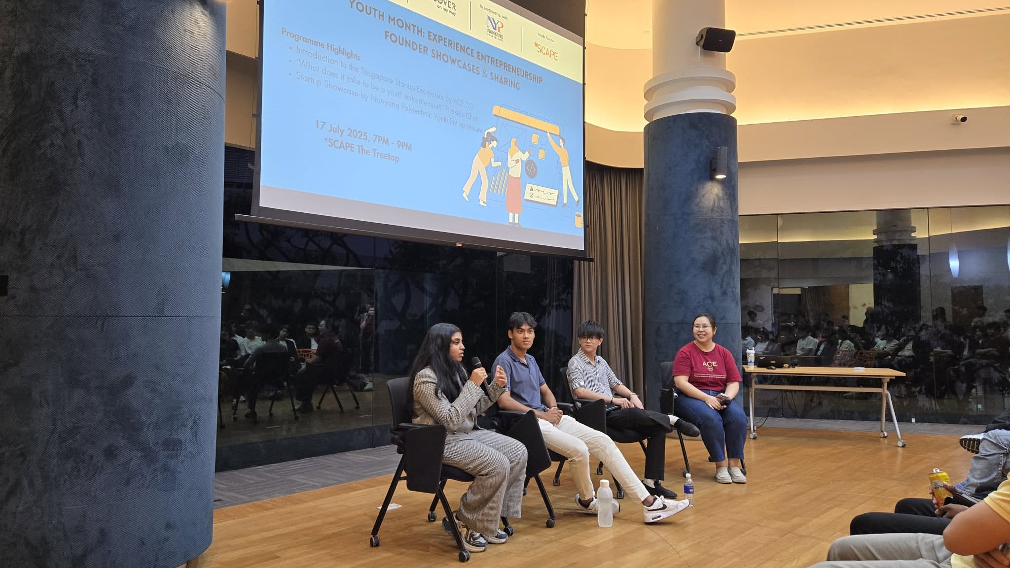 Four individuals seated on a stage facing an audience