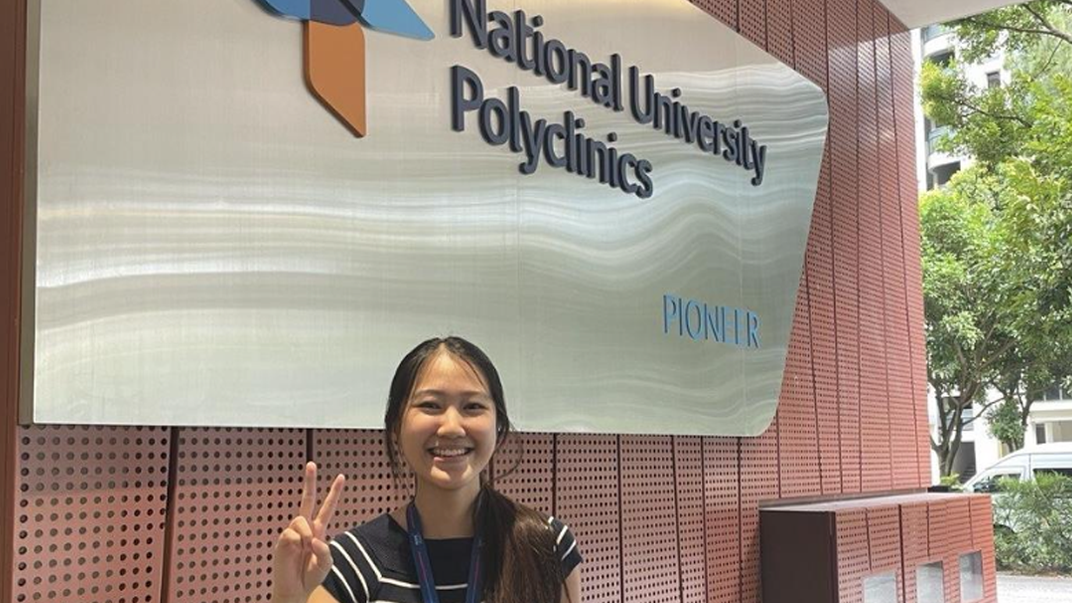Glenda at the entrance of National University Polyclinics