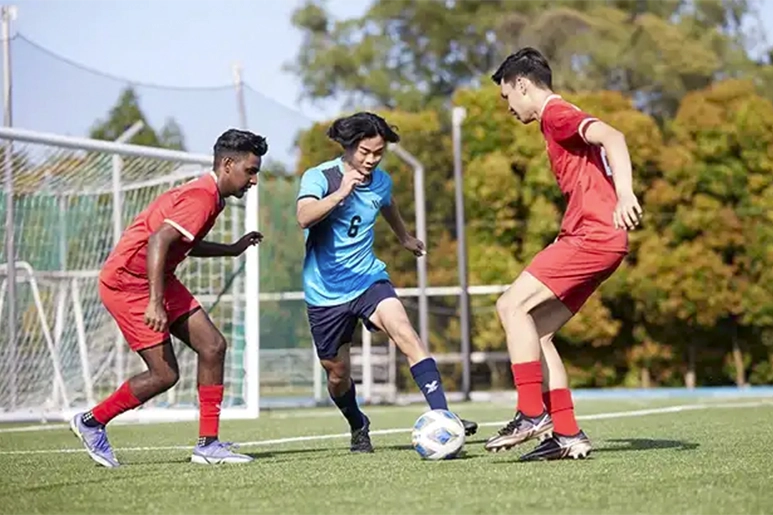 Soccer players dribbling a ball on the soccer field