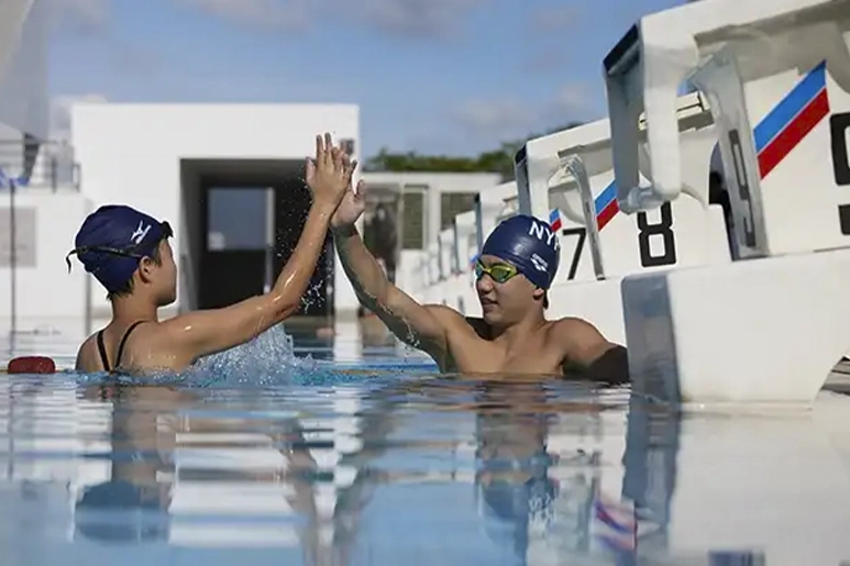 Two swimmers giving each other a high-five