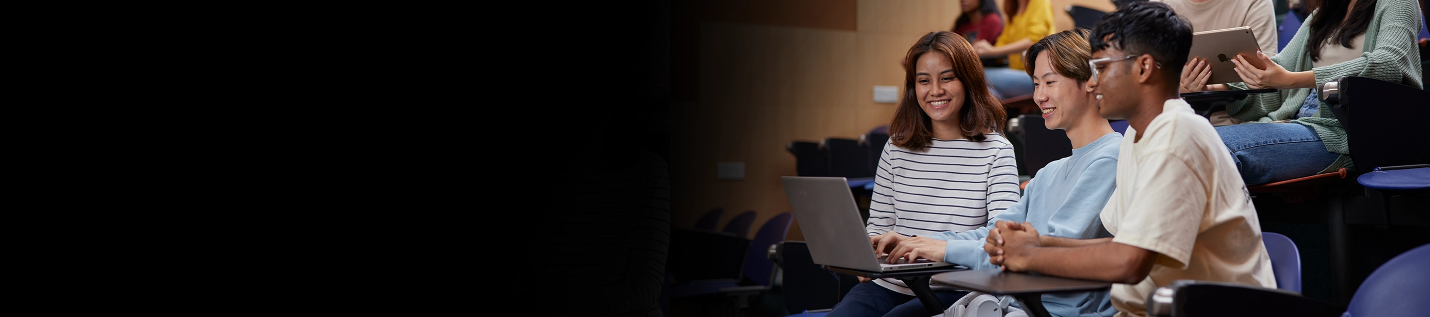 Students browsing their devices in a lecture theatre