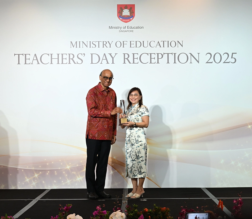 Lina Tan and Singapore President Tharman Shanmugaratnam poses for a picture on stage.