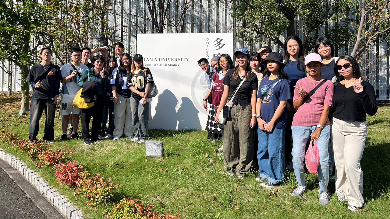 Group photo of students with a plaque of Tama University in 2024