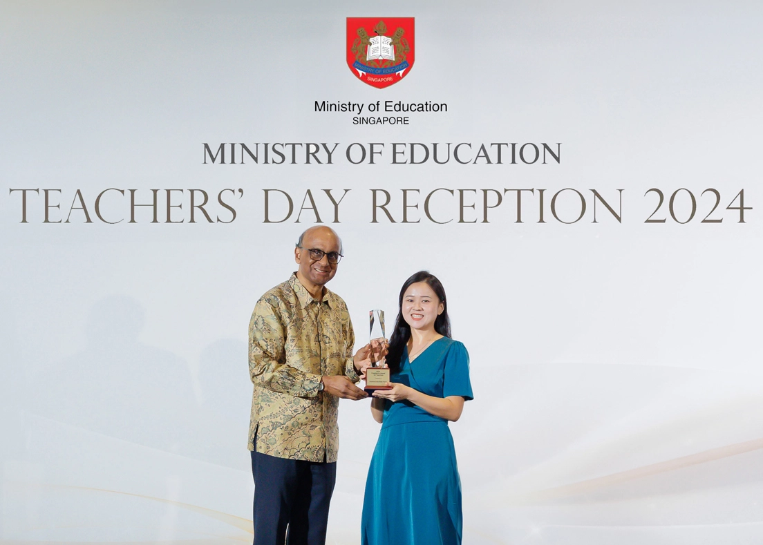 Eunice and President Tharman poses for a picture on stage.