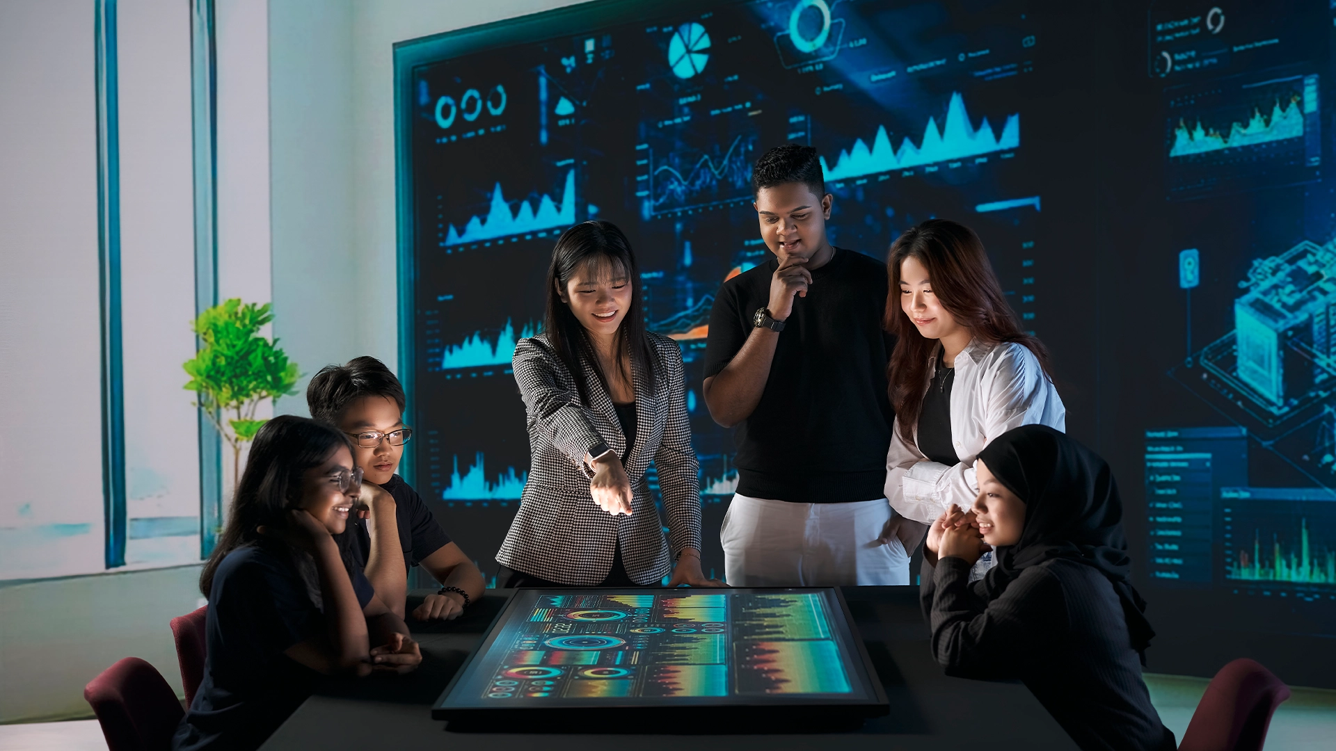 Female leader points at the screen with statistics in a group discussion.