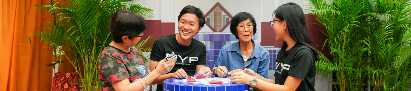 Students talking to middle-aged women at the void deck.